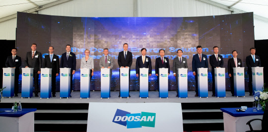 23일 헝가리 터터바녀 산업단지 내 공장 신축현장에서 열린 ㈜두산의 헝가리 전지박 생산공장 착공 기념행사에서 야노스 벤쉬크 헝가리 국회의원(왼쪽 여섯째부터), 시야르토 피터 헝가리 외교통상부 장관, 동현주 ㈜두산 부회장 등이 세레모니에 참여하고 있다. <㈜두산 제공>